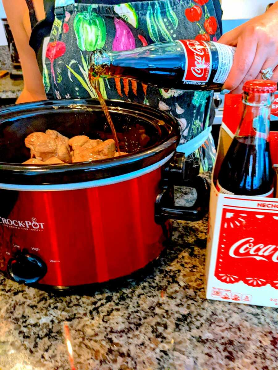 adding Coca-Cola to the pork in the slow cooker