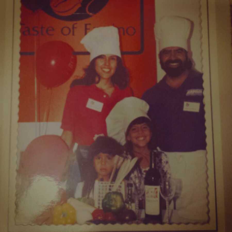 family stands together wearing chef hats