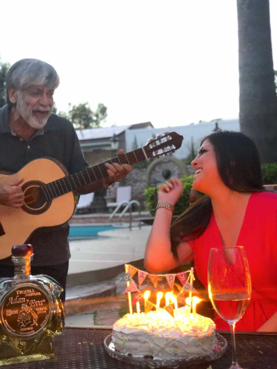 Woman looks lovingly at her father while he sings her happy birthday