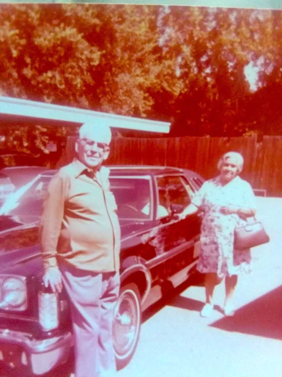 old picture of woman's grandparents standing near a car