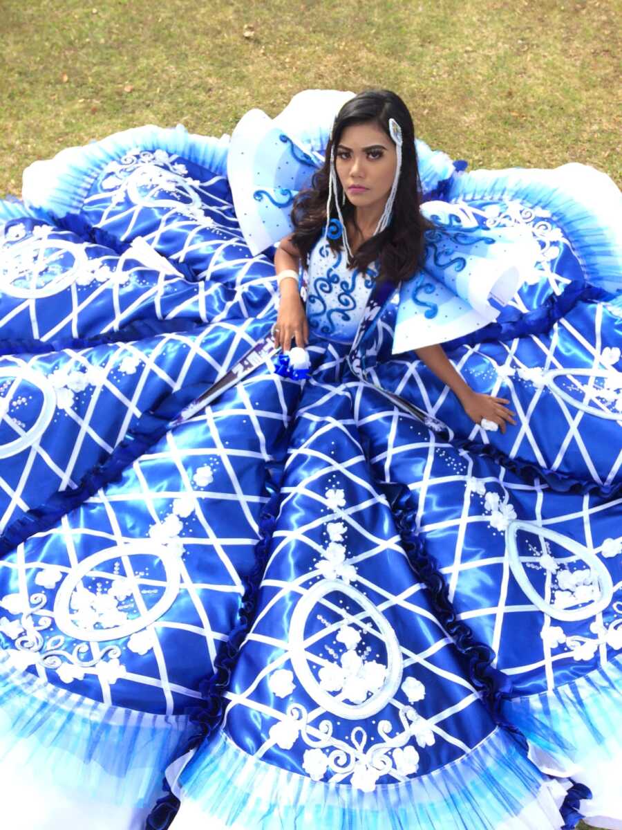 girl sits on the ground with her prom dress spread around her