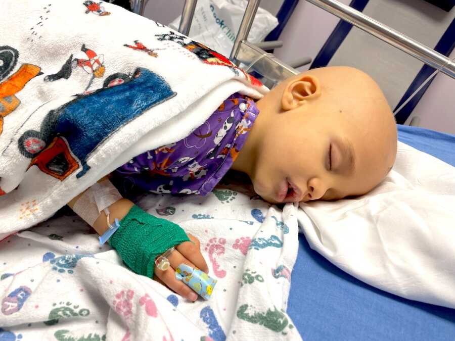 boy with childhood cancer lays sleeping in the hospital