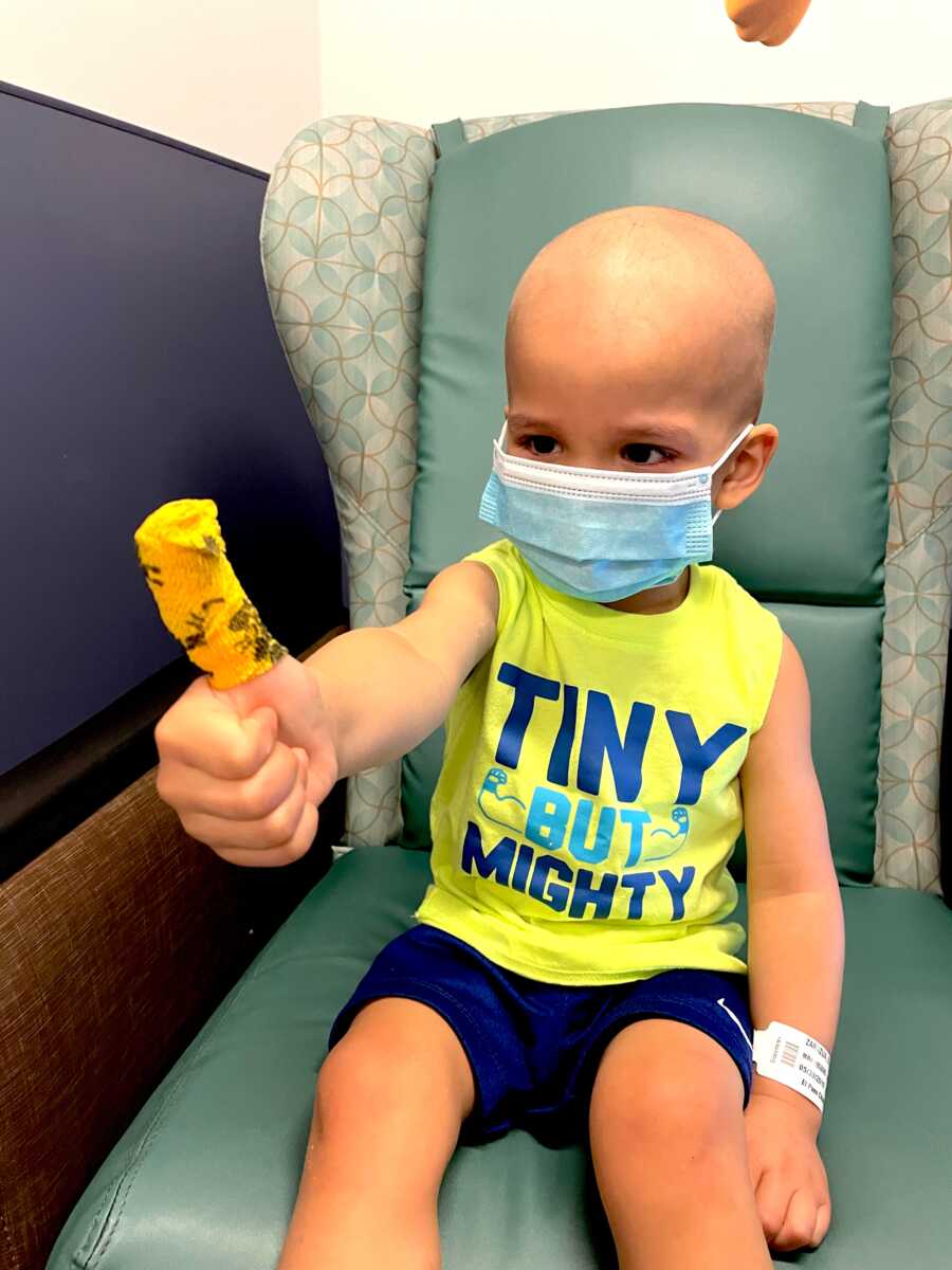 boy with childhood cancer gives a thumbs up