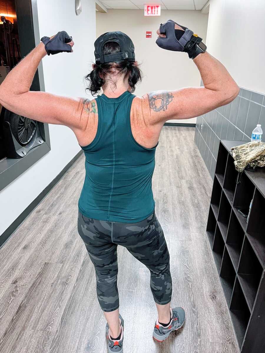 A woman flexing her back at the gym