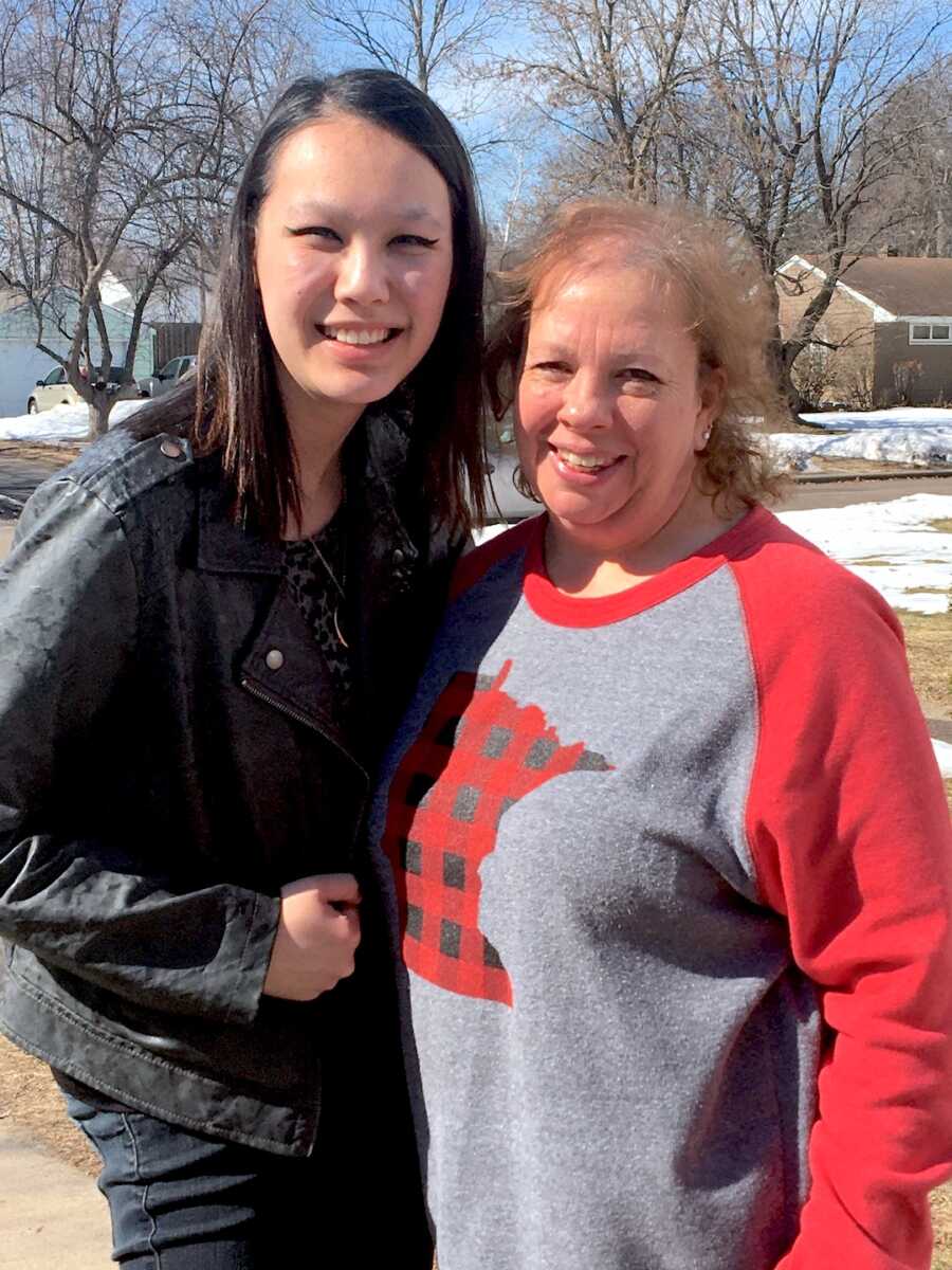 adoptee stands with her adoptive mother, both smiling