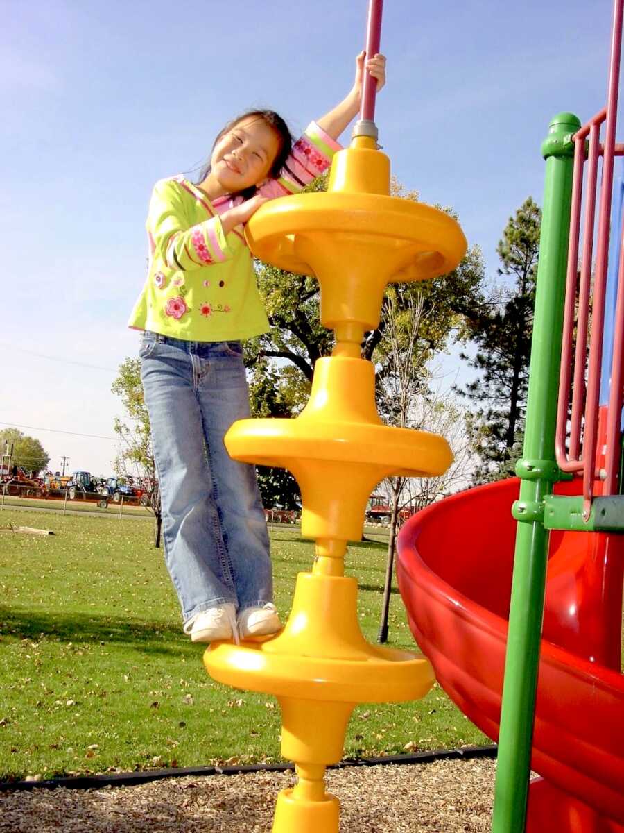 young adoptee plays on the playground