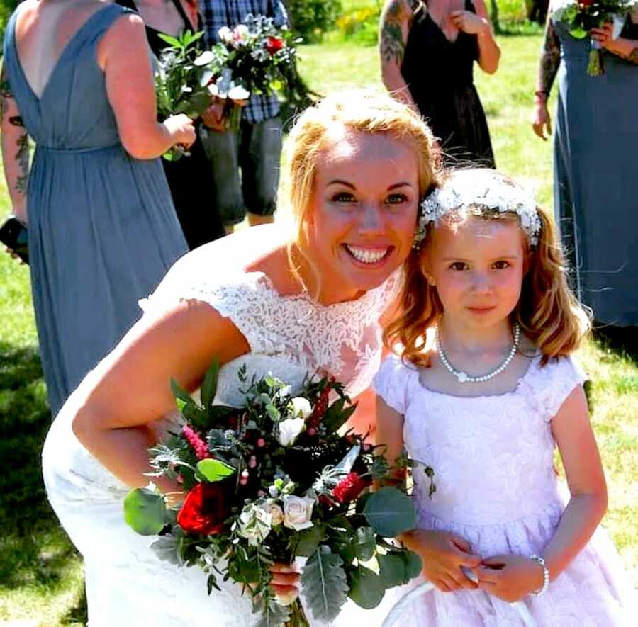 mother on her wedding day stands with her daughter