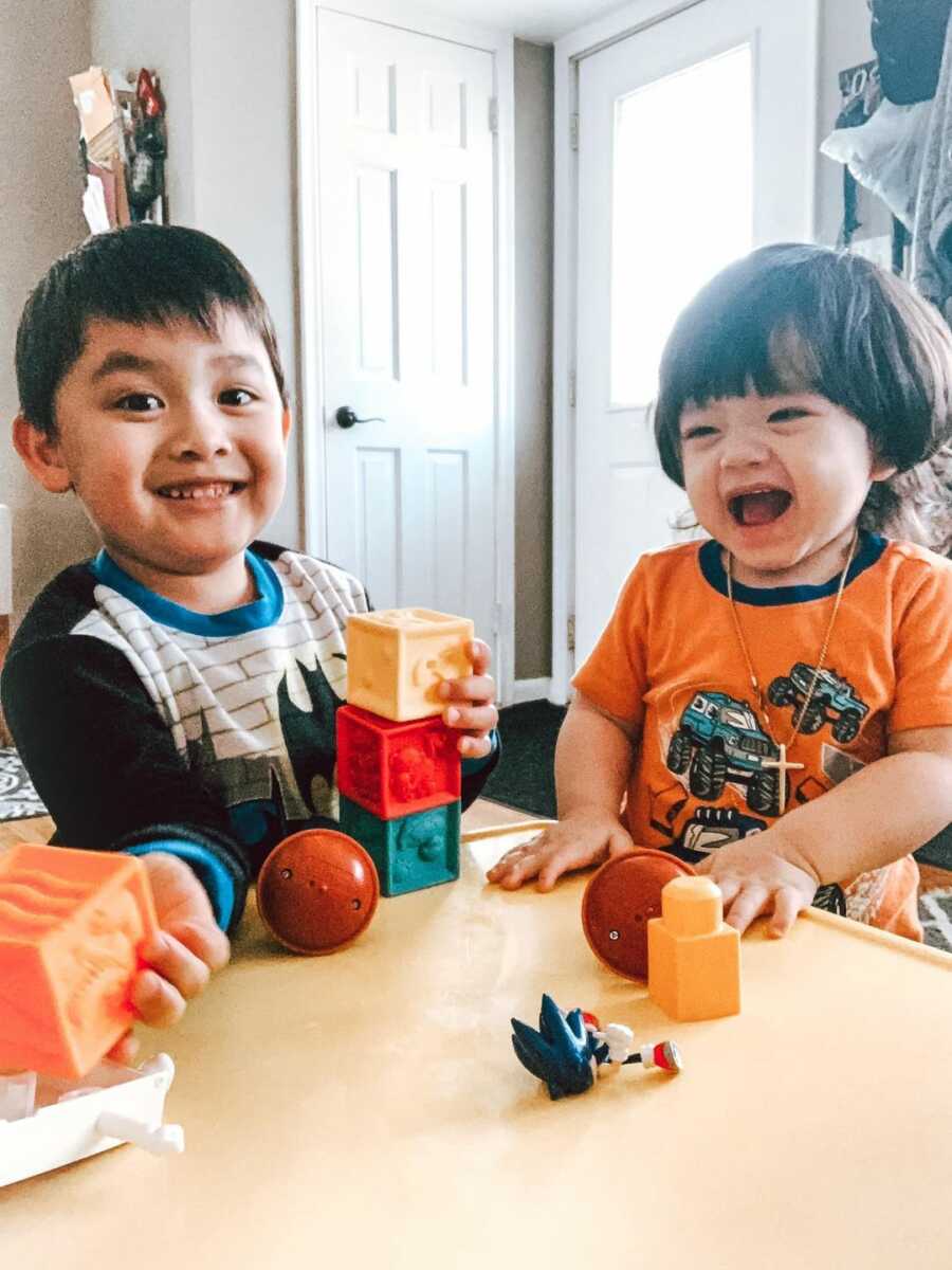 two young children smiling and playing together