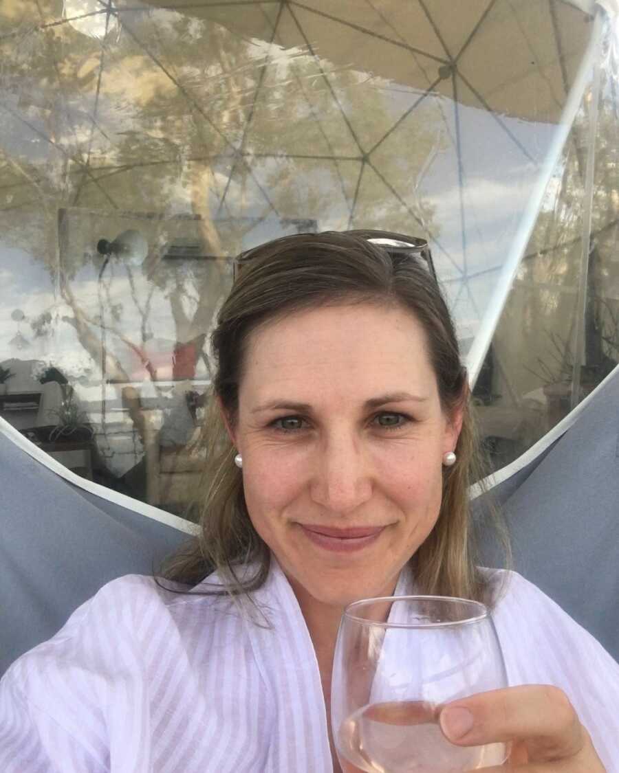 mom sitting down with a glass of wine in hand