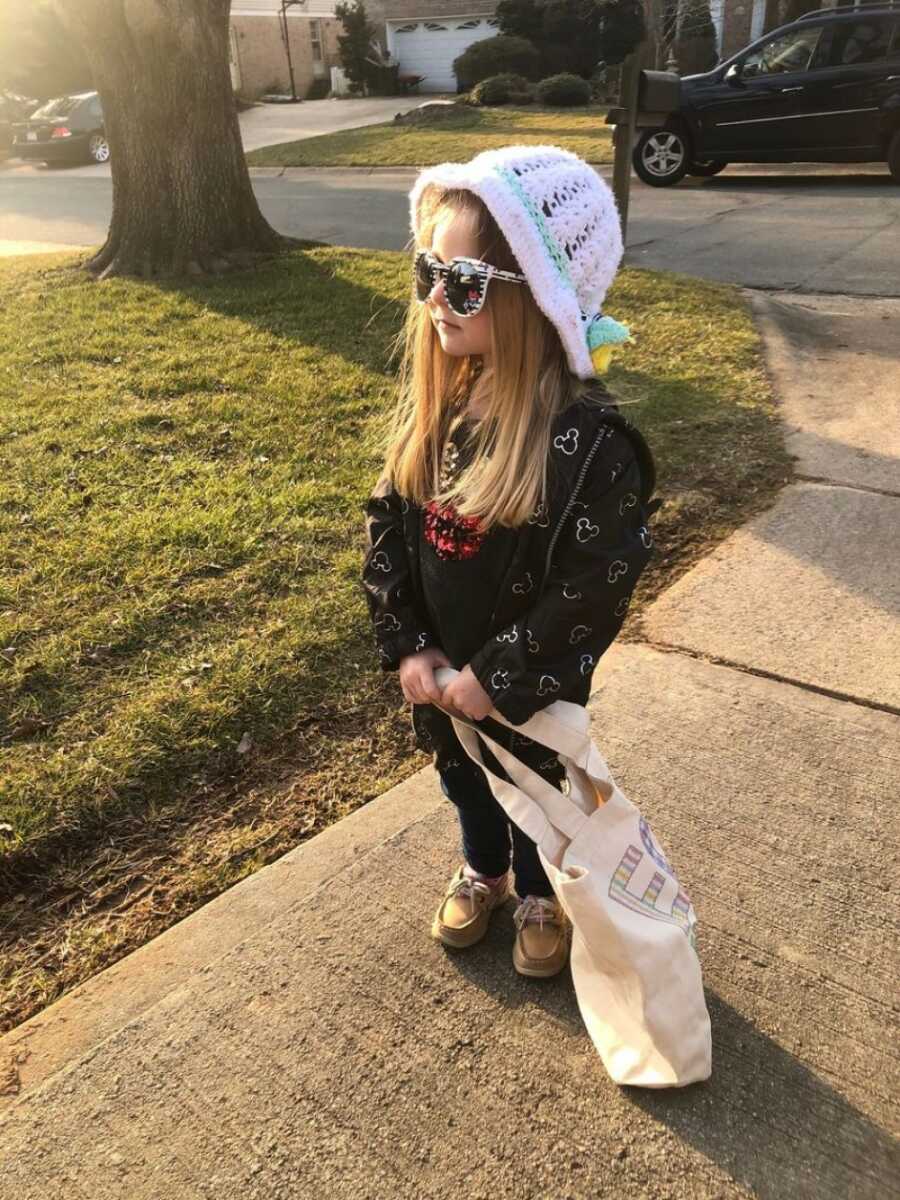 little girl standing on the sidewalk not caring