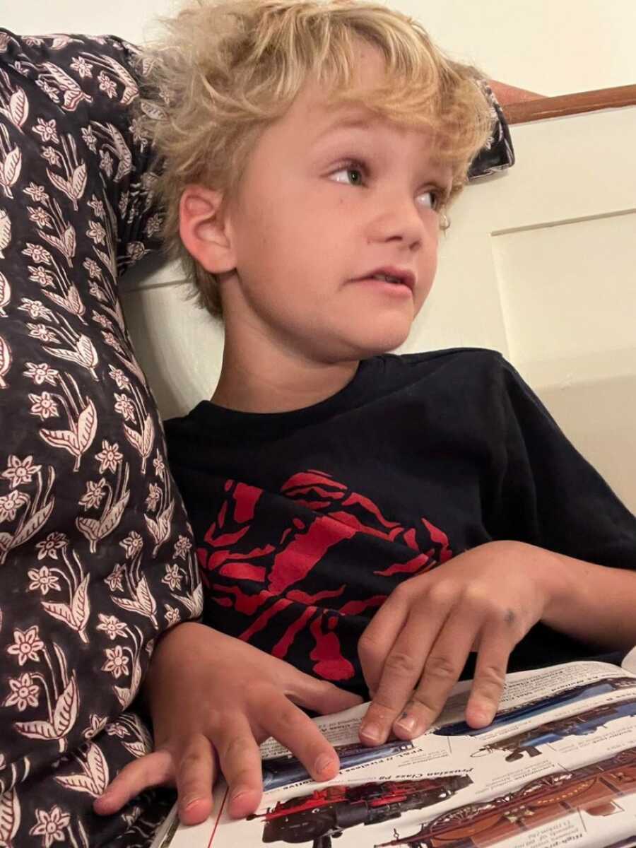 little boy with autism reading a book