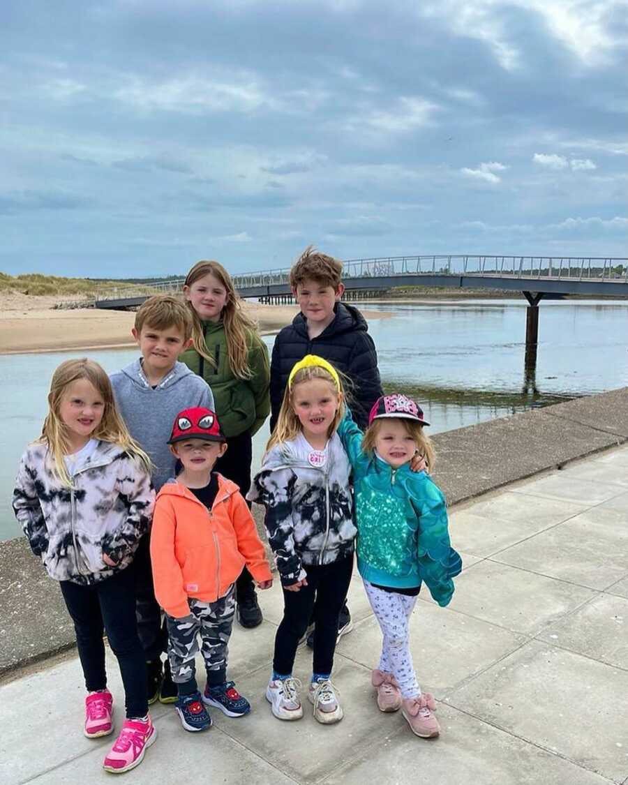 brothers and sisters smiling together by water