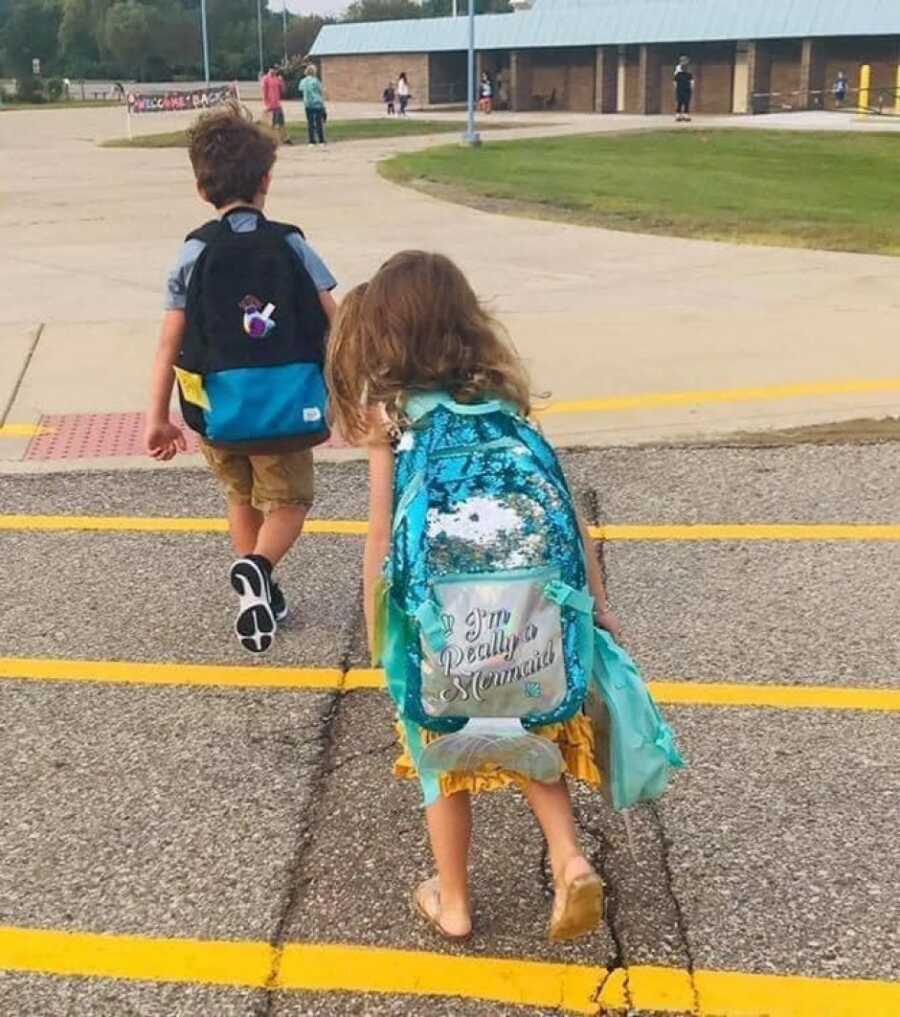 brother and sister walking into school as their mom watched