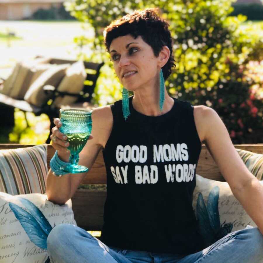 woman sitting with a glass of wine smiling 