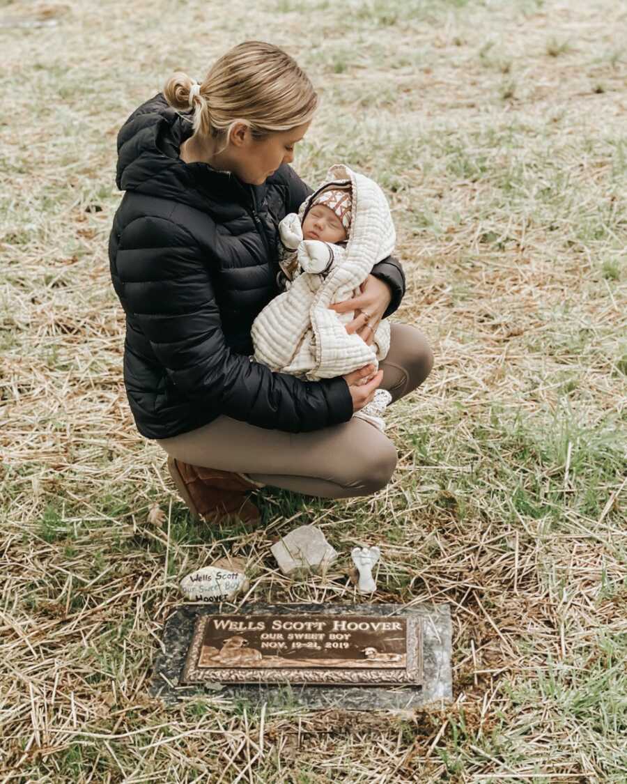 mom holding daughter taking her to sons grave