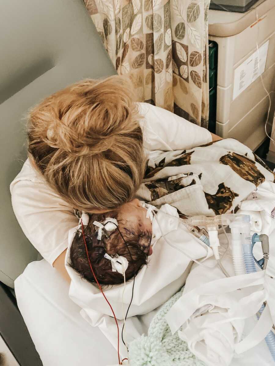mom holding her son close while they are in the hospital