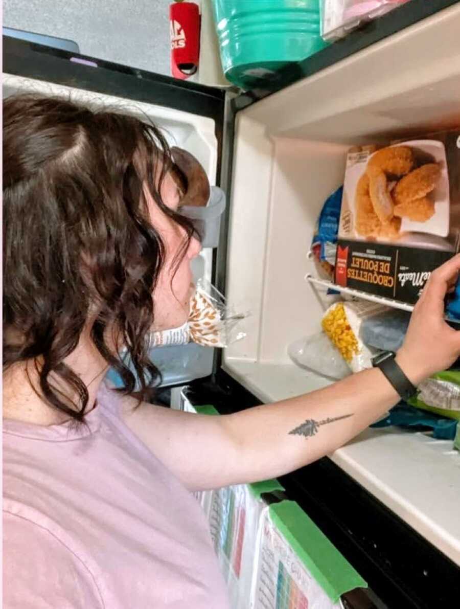 Mom looks into the freezer while trying to plan dinner