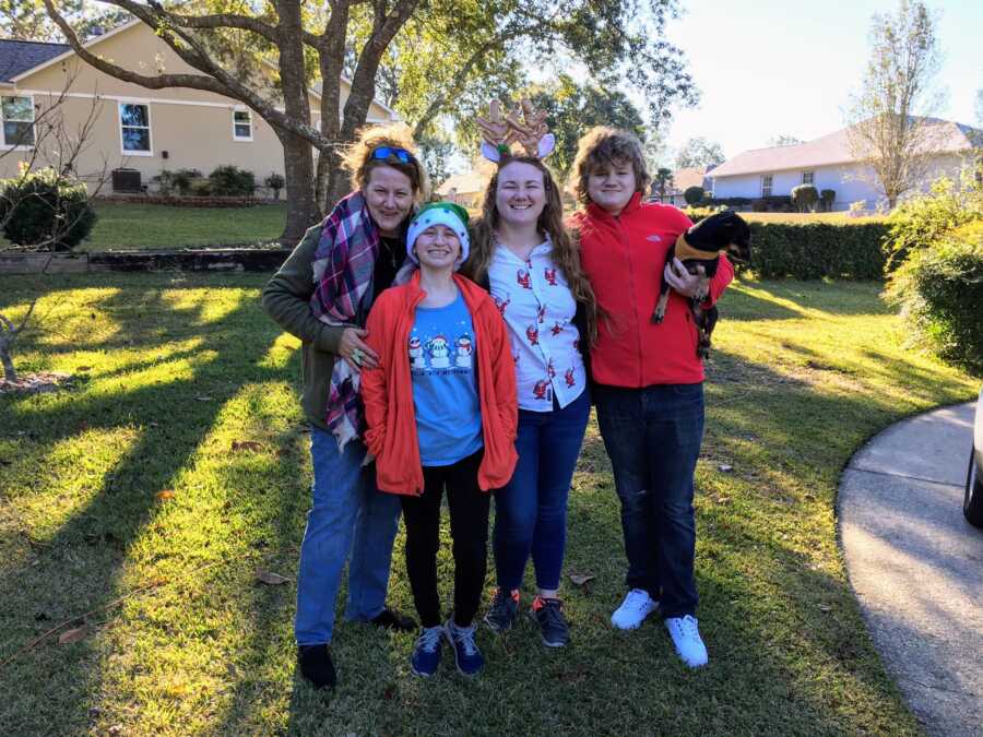 Family take group photo while wearing Christmas-themed clothes on Christmas day