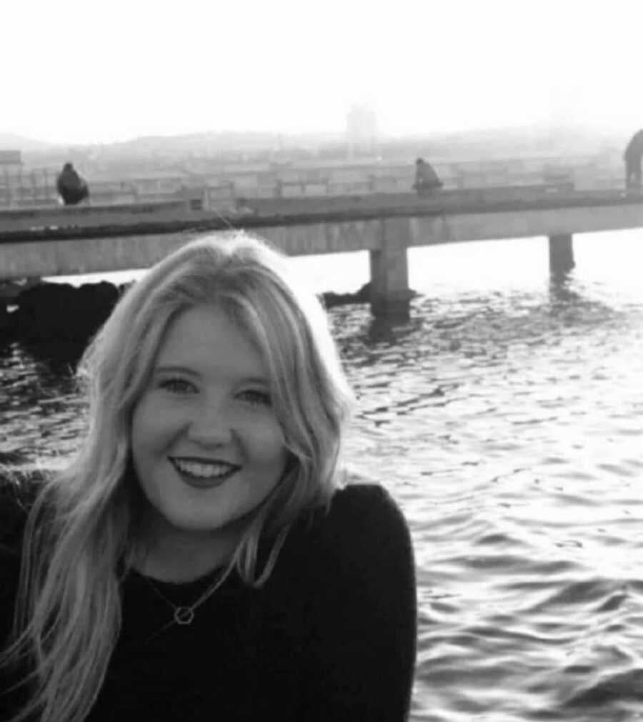 woman sitting by the water, black and white photo
