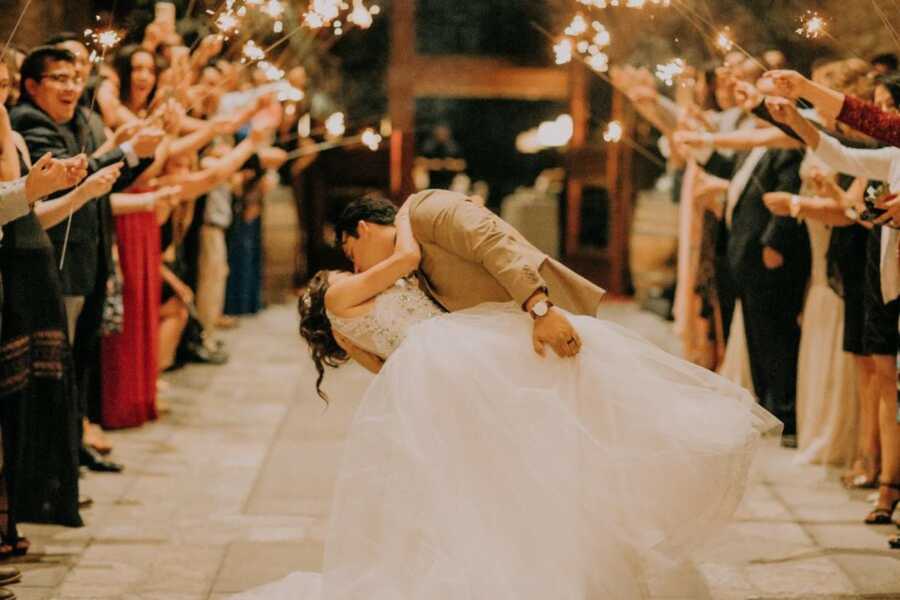 man and wife kissing on the day of their wedding