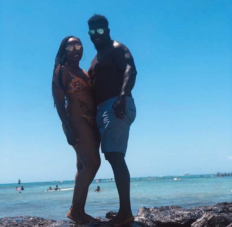 A woman and her husband stand together at a beach