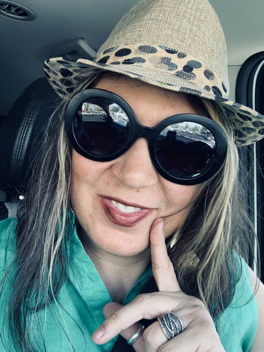 A woman with MS wearing sunglasses and a hat