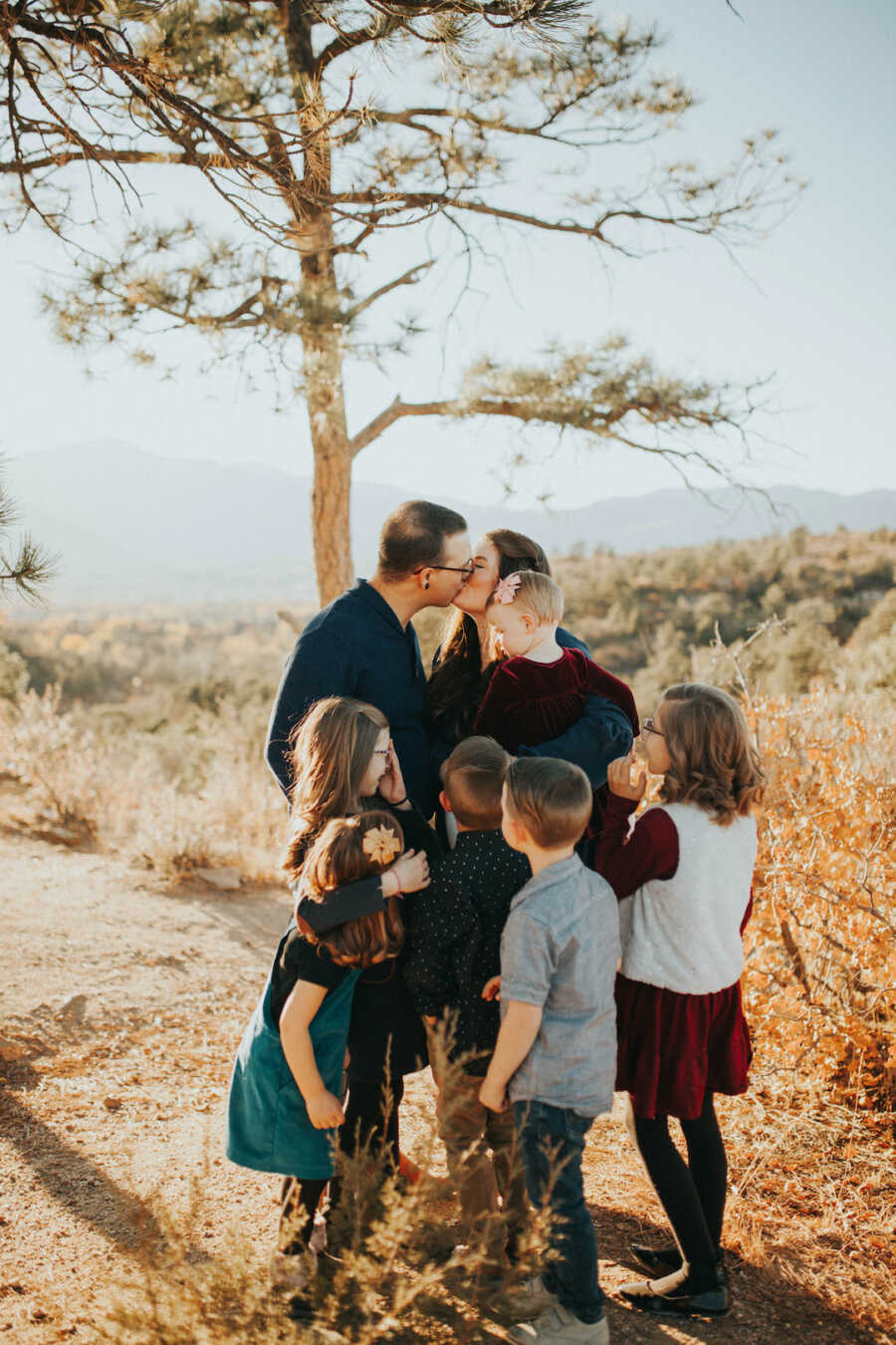 woman and man kissing with children watching them 