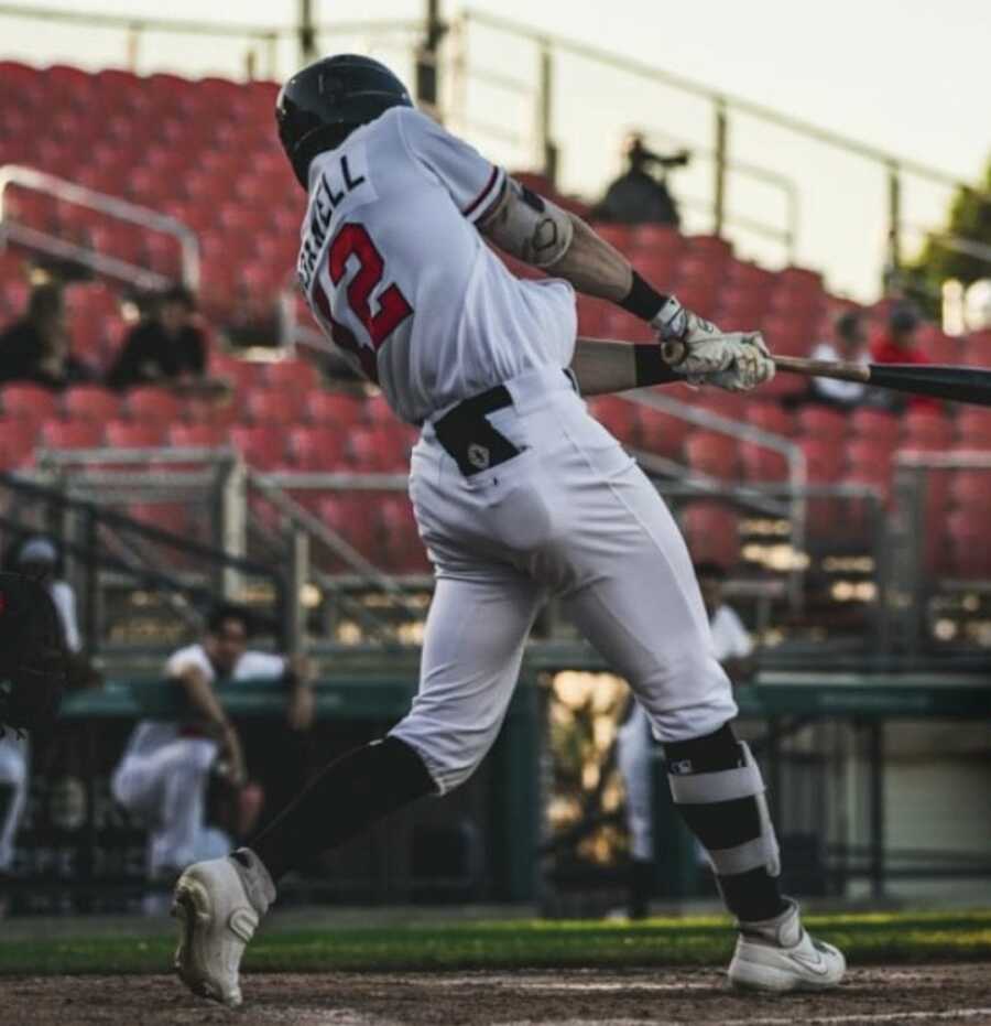 Man hitting a baseball on a field