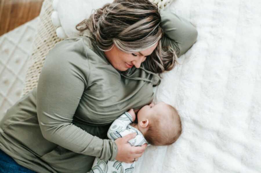 mom and child breastfeeding on the bed