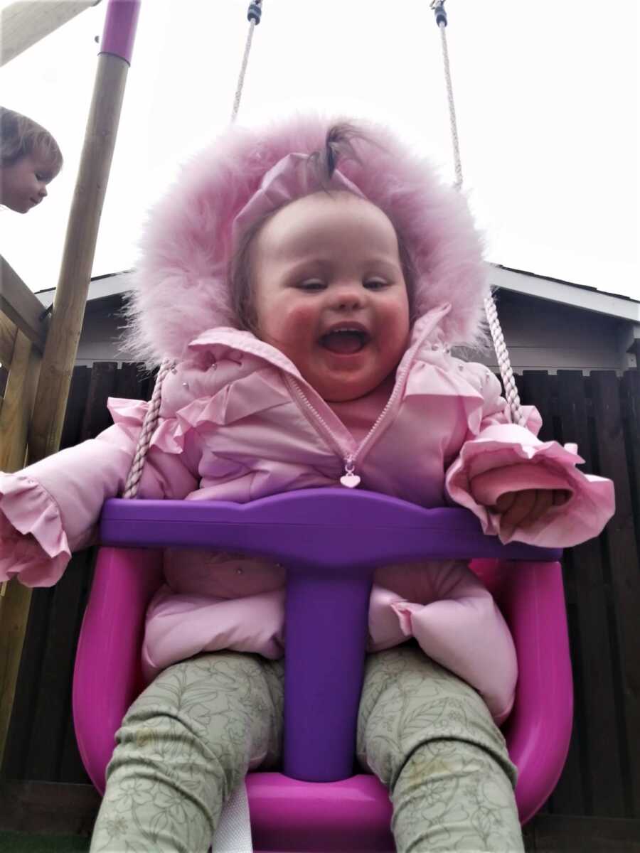 daughter with down syndrome playing in the swing
