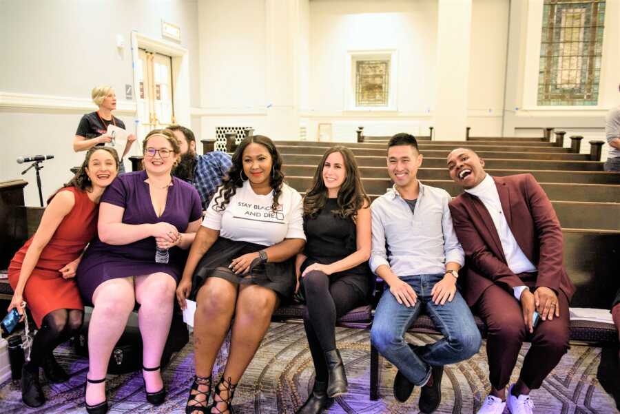 Group of young people at church sitting in the first row looking happy and smiling