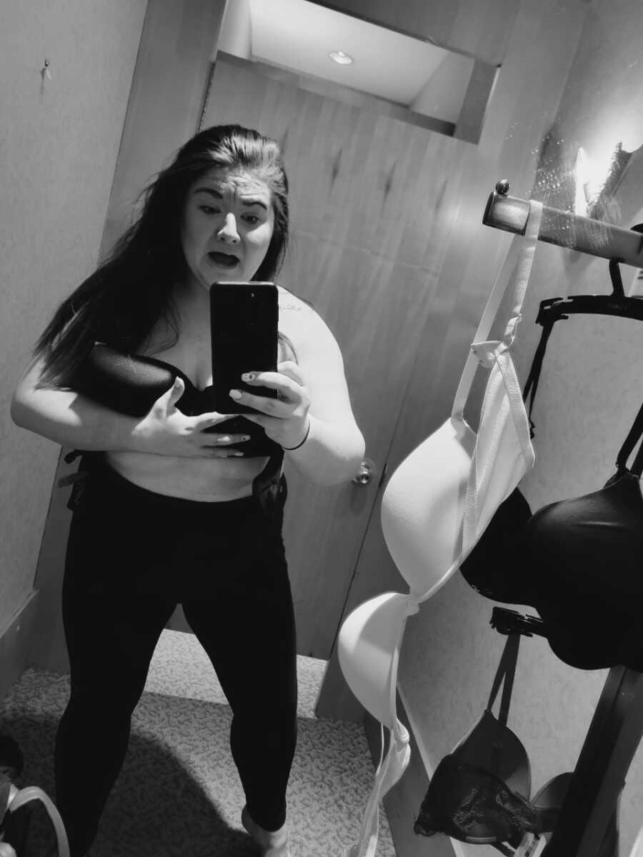 woman trying on bras in a dressing room after having a baby