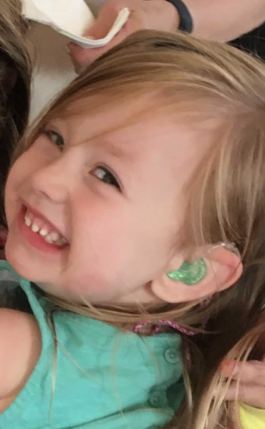 daughter smiling with her cochlear implant