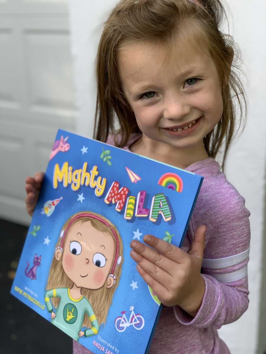 little girl holding the book written for her