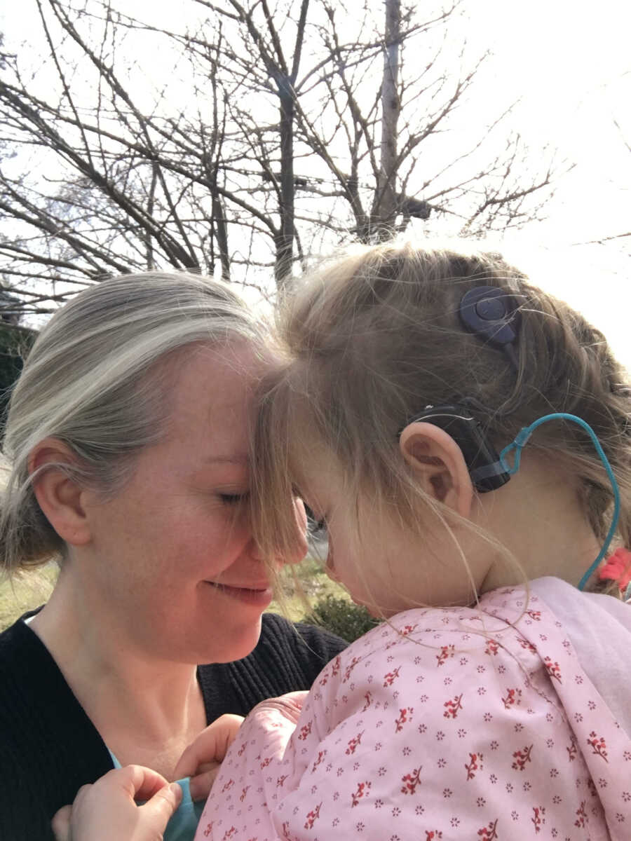 mom and daughter holding each other close