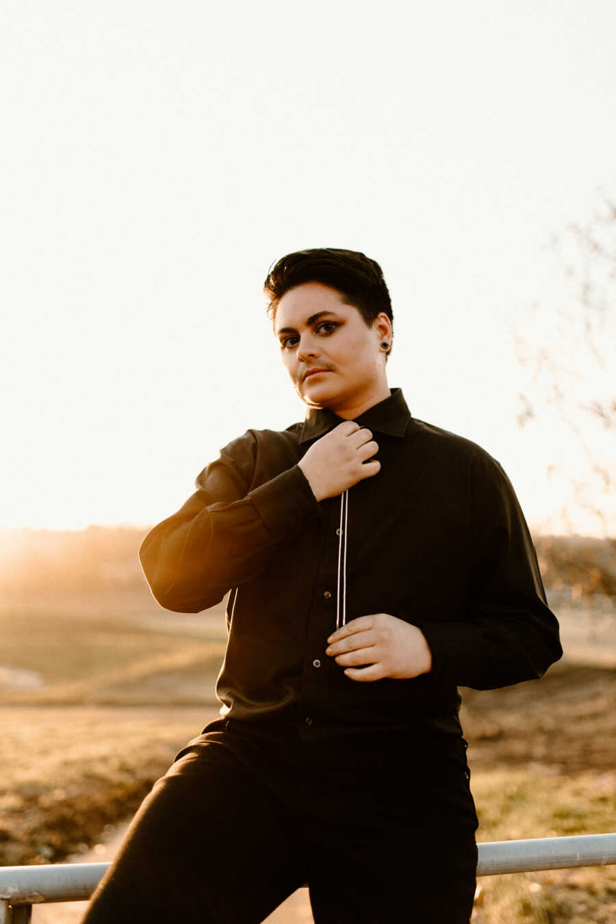 non binary person posing at sunset