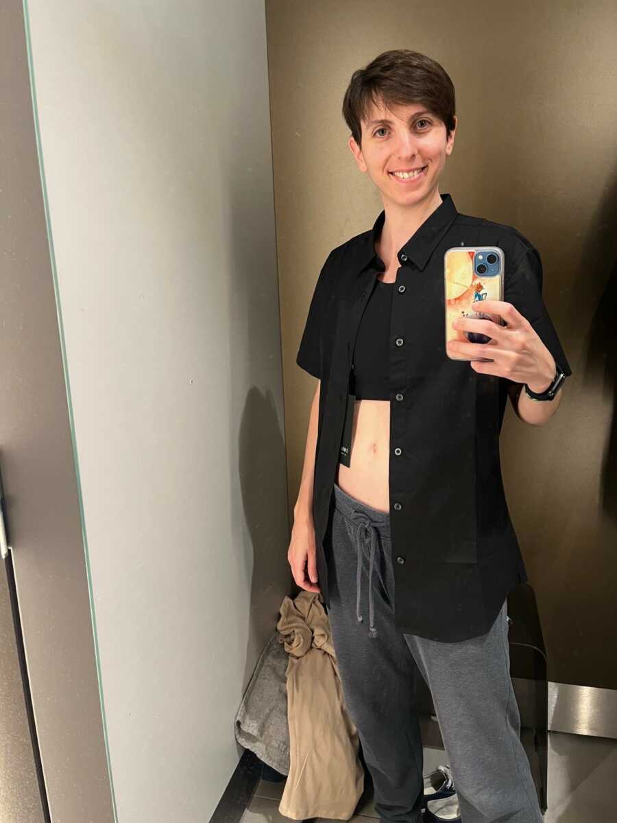 non binary person showing off their binder