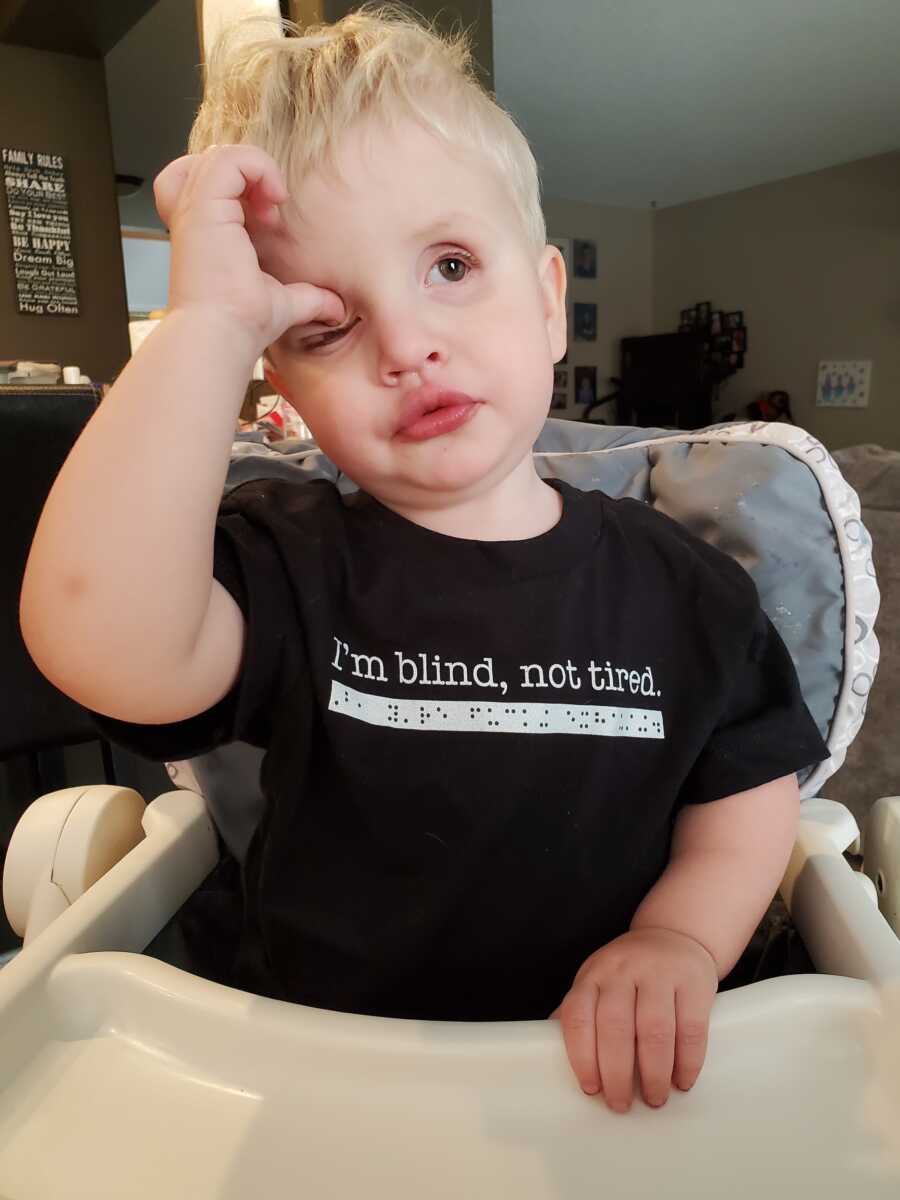 son with blindness in his high chair