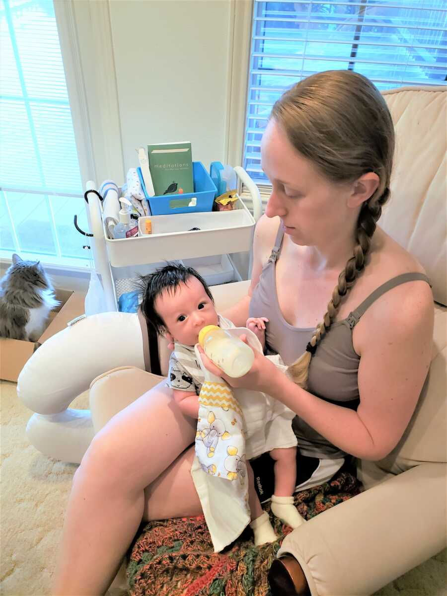 New mom bottle feeding her newborn son at the hospital 