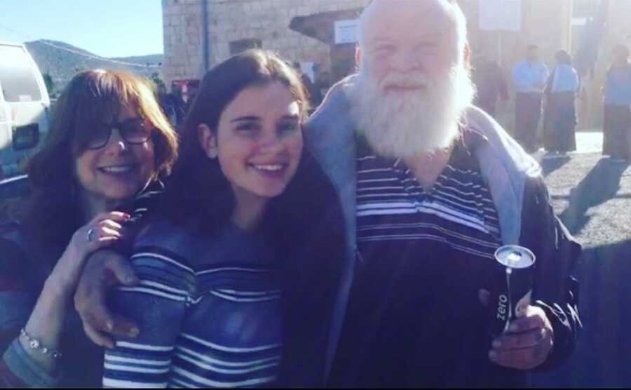 mom dad and daughter smiling together