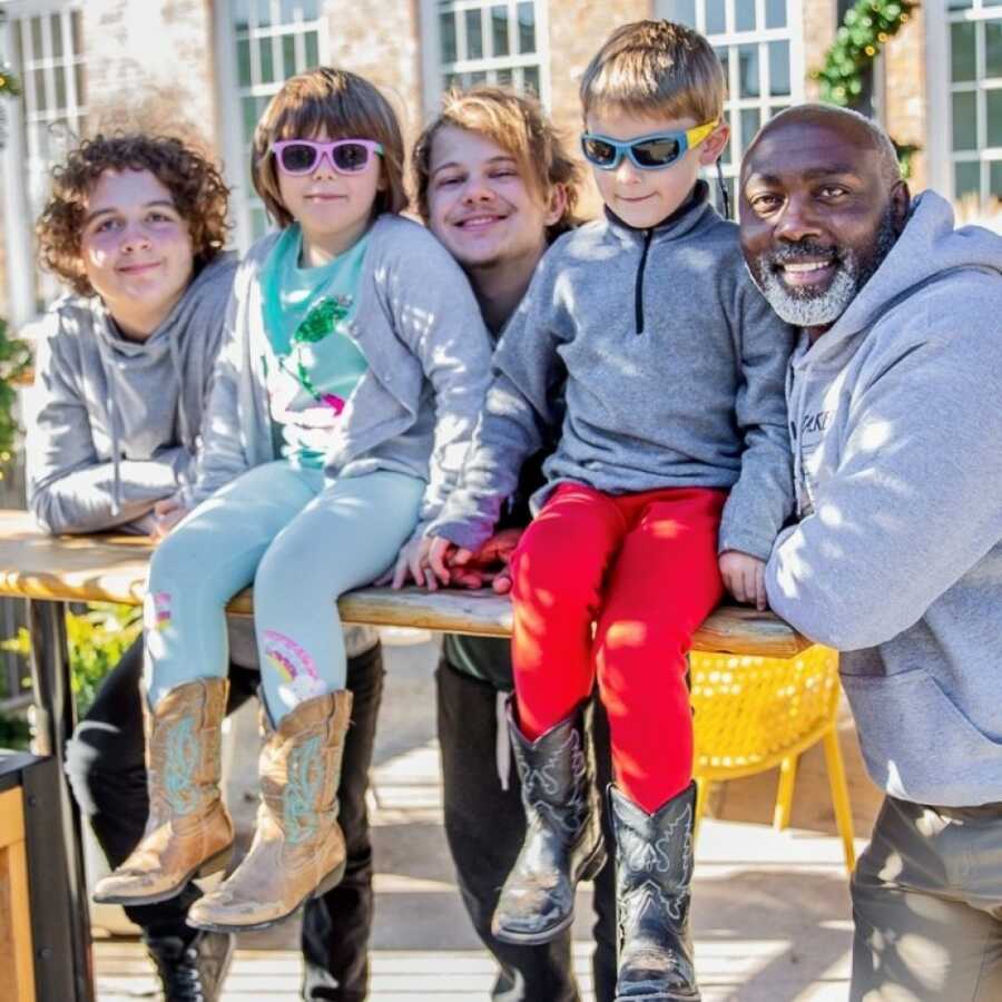 dad and foster children smiling and enjoying the day