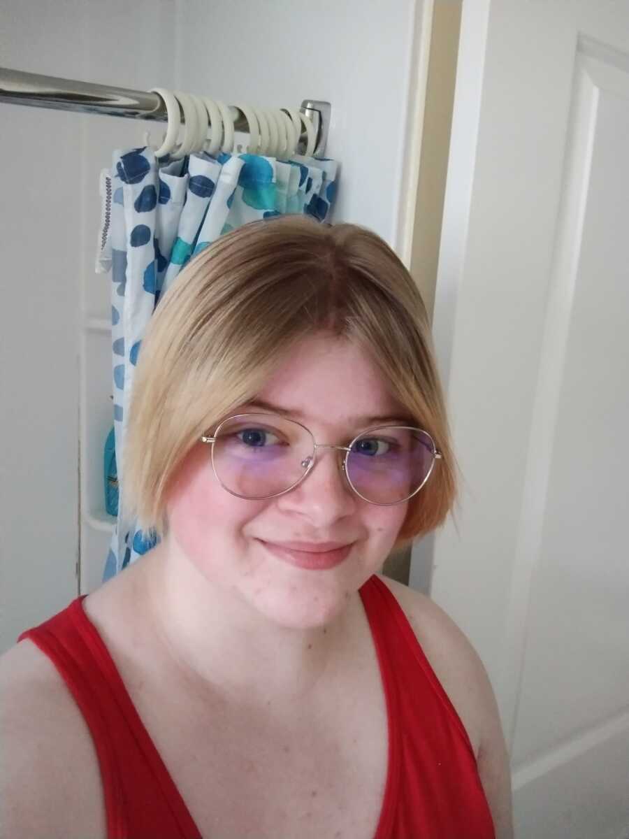 non binary person in glasses taking a selfie