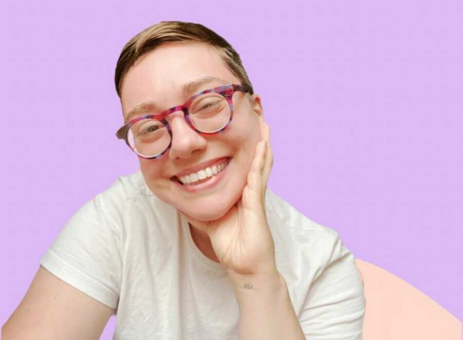 non binary person showing their glasses