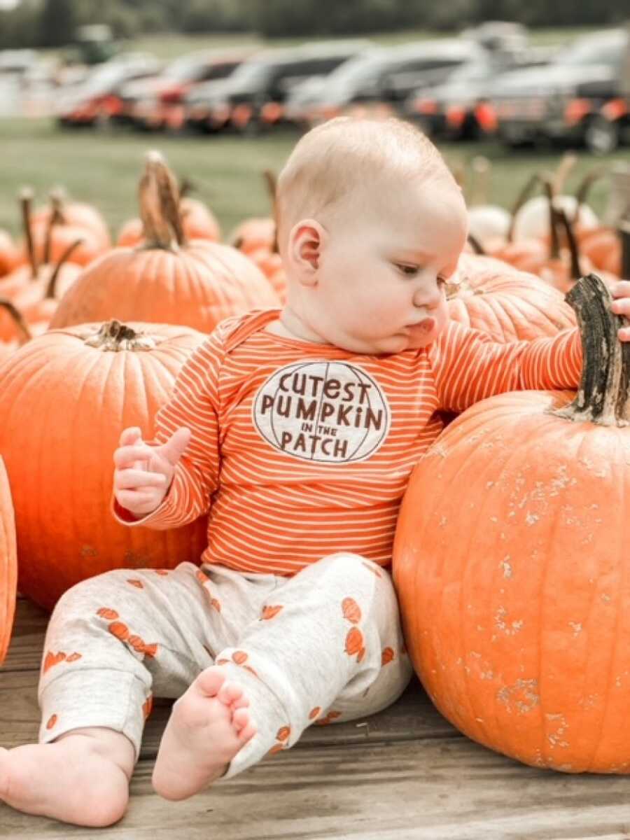 baby boy in a pumpkin patch