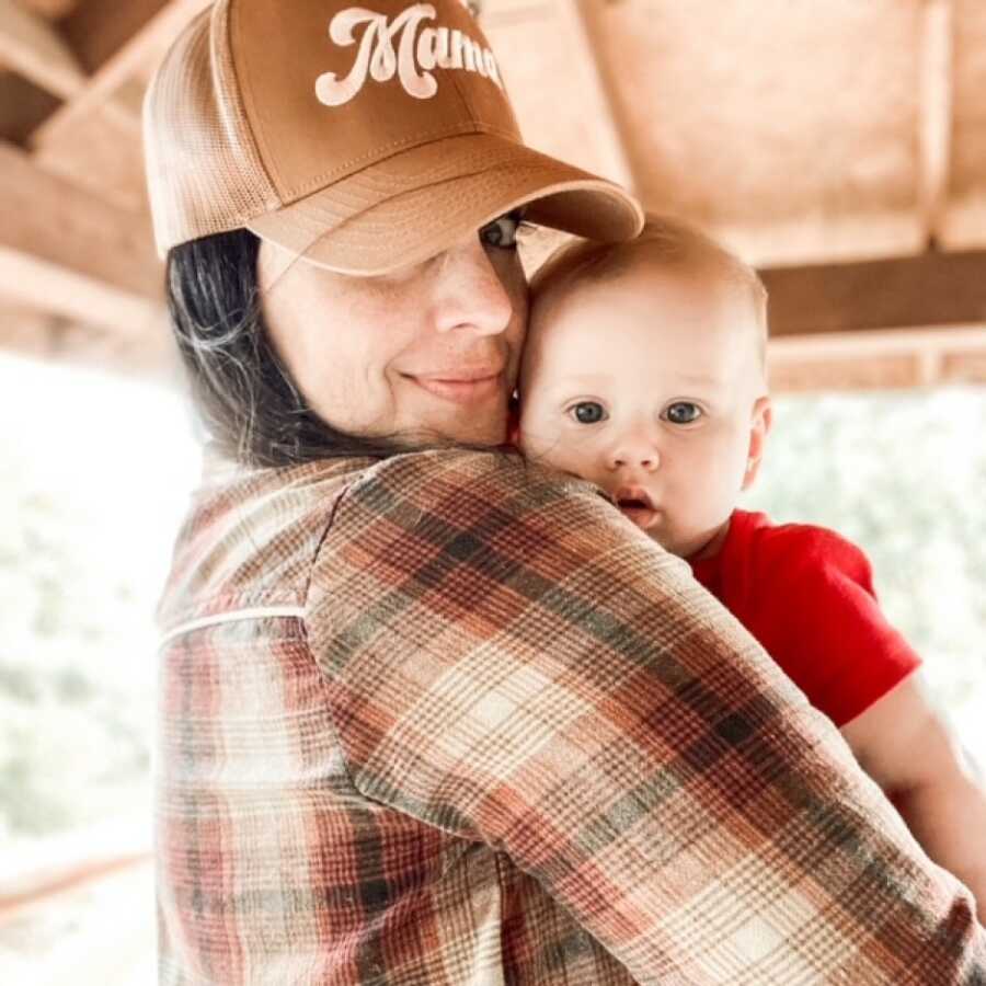 mom holding her son close and smiling
