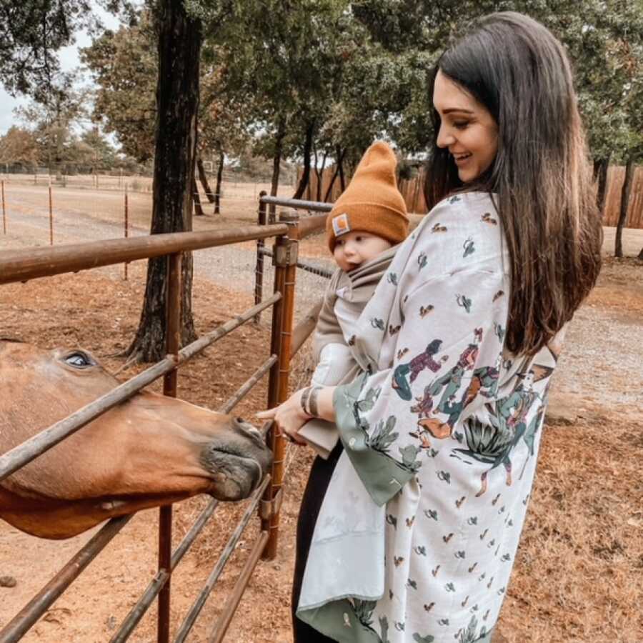 mom and son feeding their horse on their farm