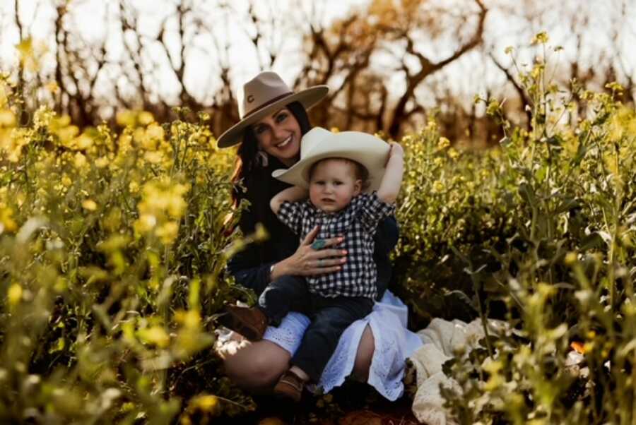 mom and son in cowboy hats in a field