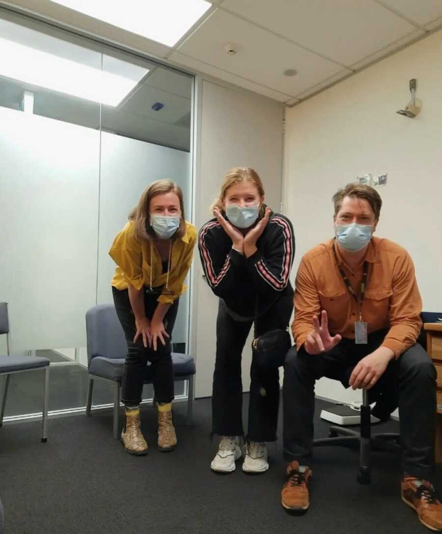 women with a man smiling with masks on 