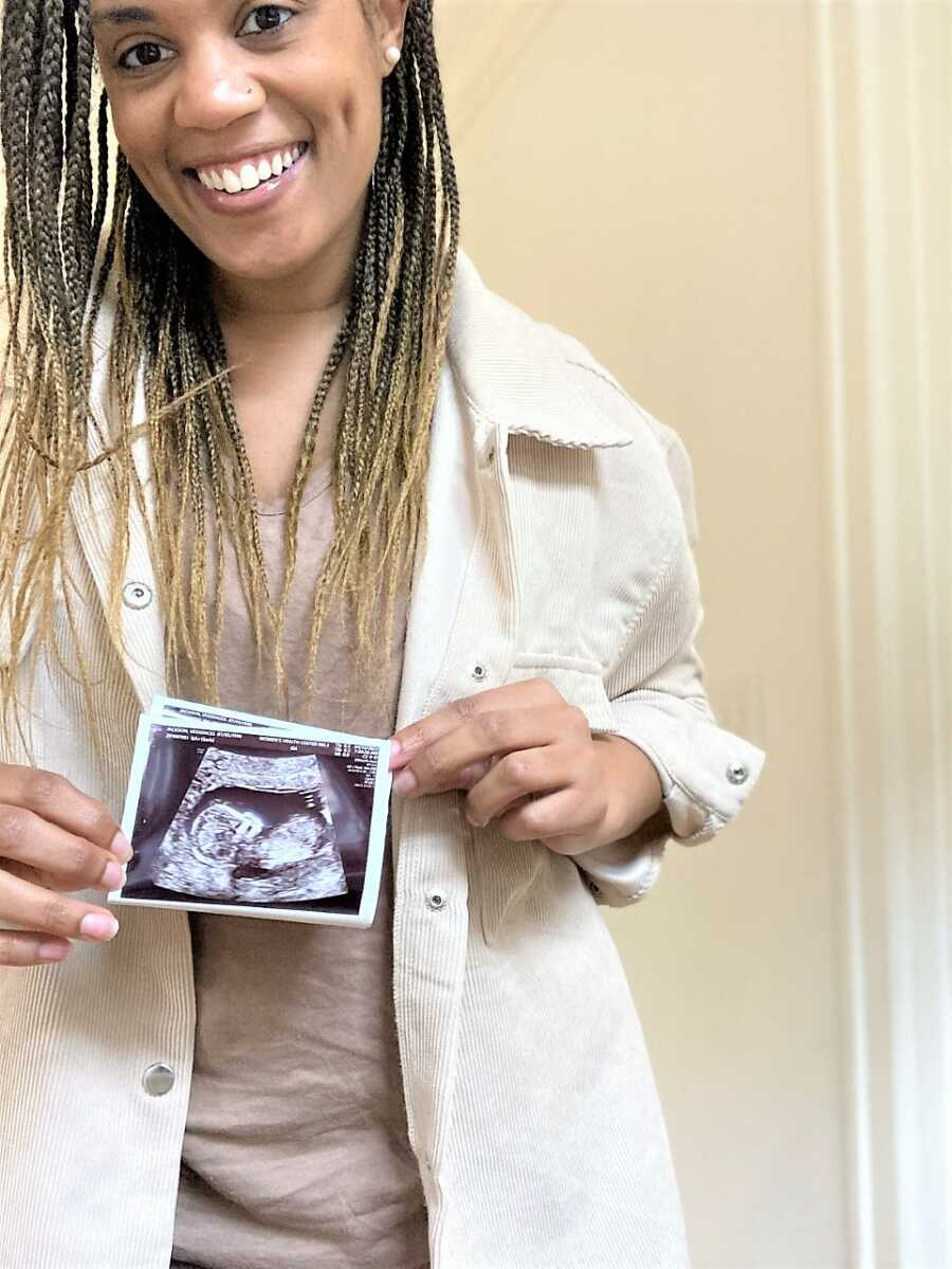 pregnant woman holding the fetal ultrasound of her baby