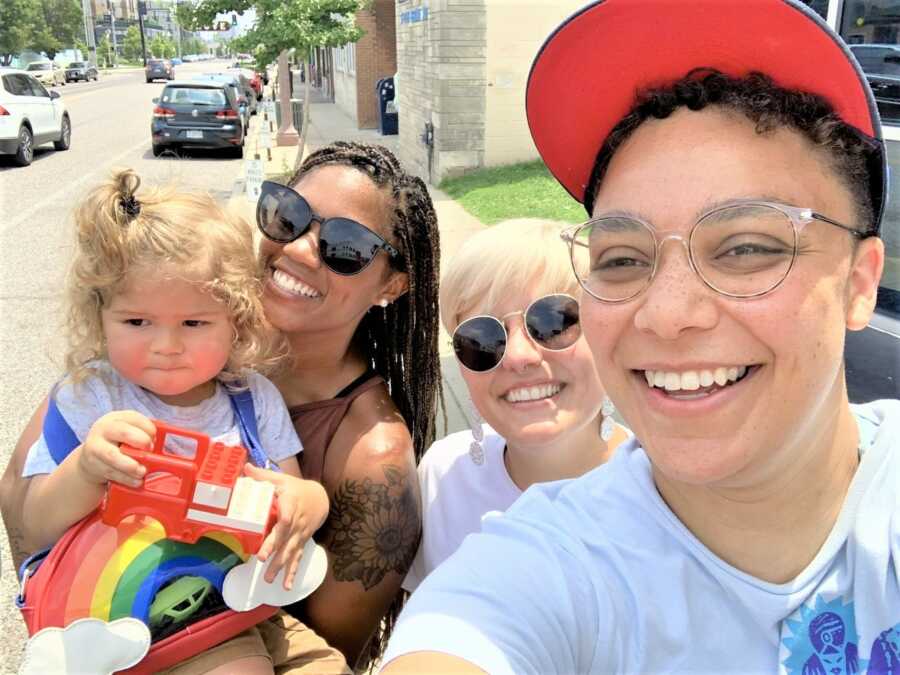 woman holding a baby girl hanging out with two friends 